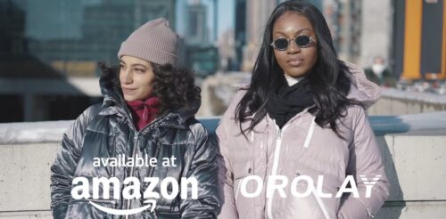 Two people wearing winter coats, one in a beanie and the other in sunglasses, with the text "available at Amazon Orolay" overlaid on the image.