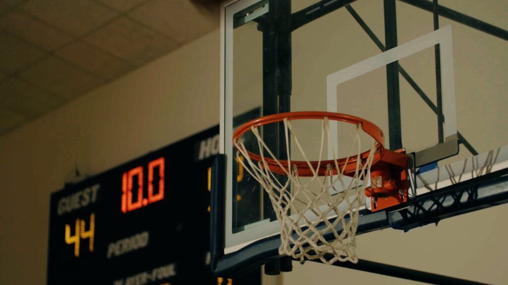 A basketball hoop with a net is in the foreground, and a scoreboard in the background shows a score of 44 and a timer at 10.0 seconds.