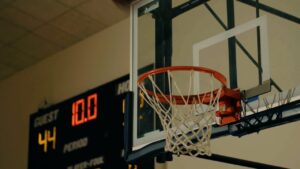 A basketball hoop with a net is in the foreground, and a scoreboard in the background shows a score of 44 and a timer at 10.0 seconds.