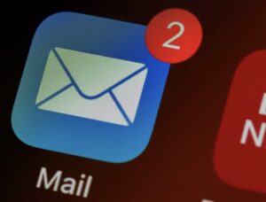 **Alt Text:** A blue email app icon with a white envelope and a red notification badge showing the number two.
