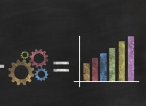**Alt Text:** A chalkboard illustration showing colorful gears on the left, an equals sign, and a multicolored bar graph on the right.