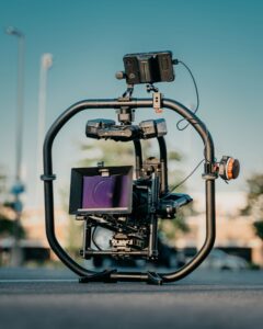 **Alt text:** A professional camera rig equipped with multiple accessories and a gimbal system is set up on an outdoor surface.