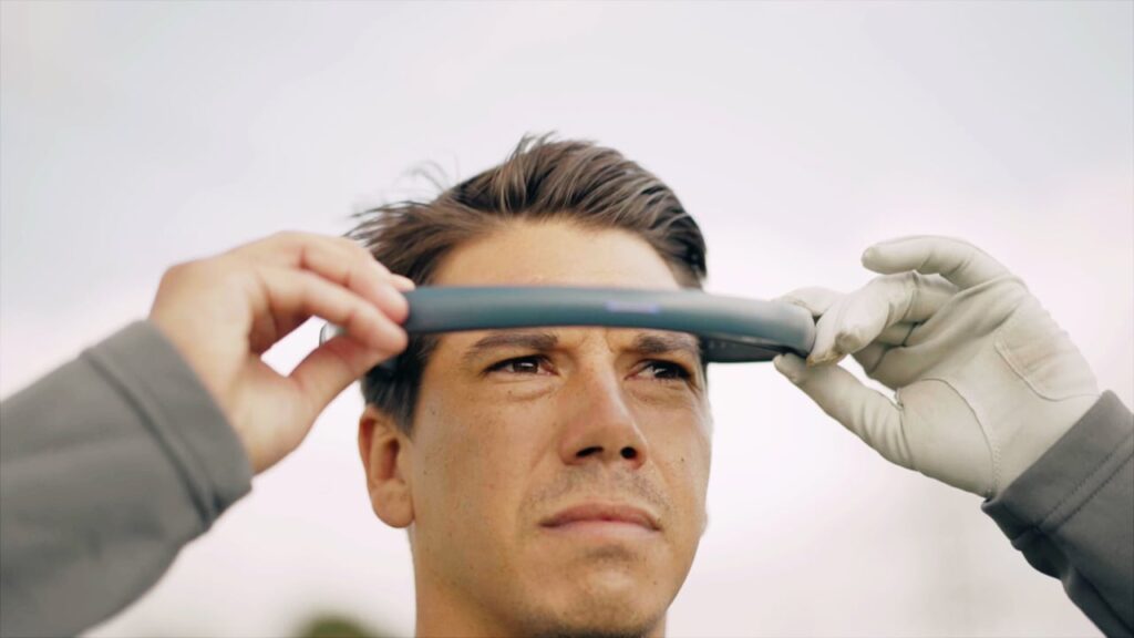 **Alt Text:** A person wearing gloves positions a horizontal viewing device or tool in front of their eyes.