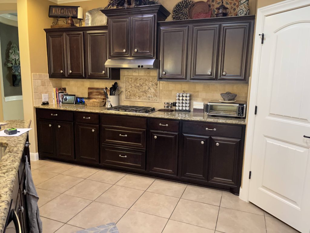 A kitchen with dark wood cabinets, a countertop with various kitchen items, and a small toaster oven.