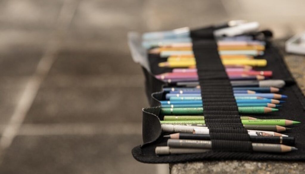 **Alt Text:** A black pencil case holds an assortment of colorful pencils neatly organized in elastic bands.