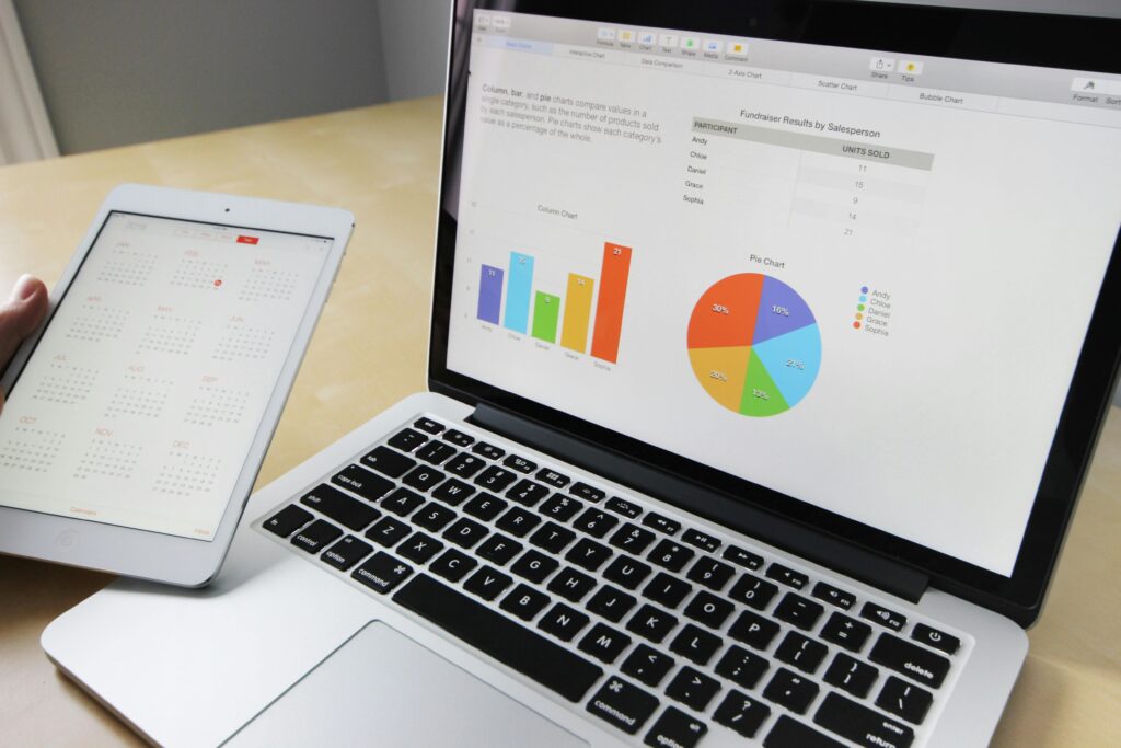 **Alt Text:** A laptop displays colorful charts and graphs next to a tablet showing a calendar.
