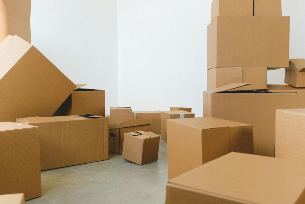 **Alt text:** A room filled with various sized cardboard boxes, some stacked and others scattered across the floor.