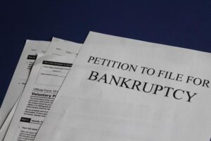 A stack of documents with the top one titled "Petition to File for Bankruptcy."