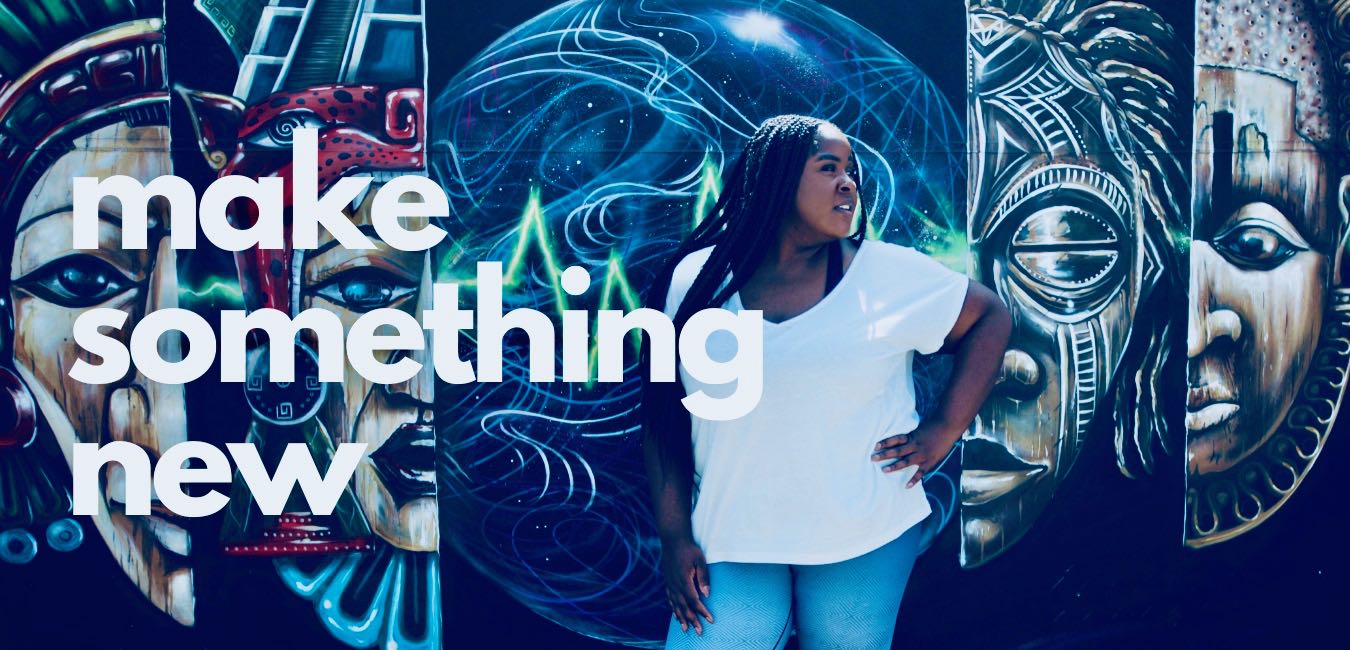 A woman in a white t-shirt stands confidently in front of a vibrant mural featuring colorful abstract and tribal face designs with the words "make something new" overlayed.