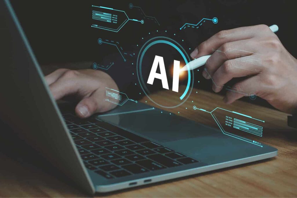 A person uses a stylus on a laptop with a holographic "AI" display above the keyboard.