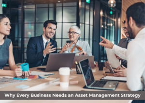 **Alt text:** A group of colleagues in a modern office discussing at a table with laptops and coffee cups, titled "Why Every Business Needs an Asset Management Strategy."