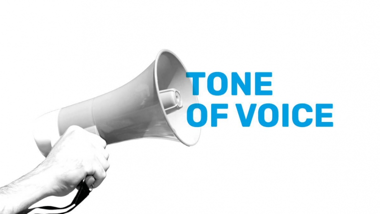 A hand holds a megaphone with the words "Tone of Voice" in blue text beside it.