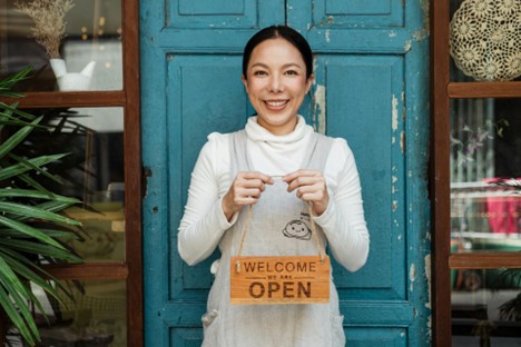 A woman stands in front of a blue door holding an 