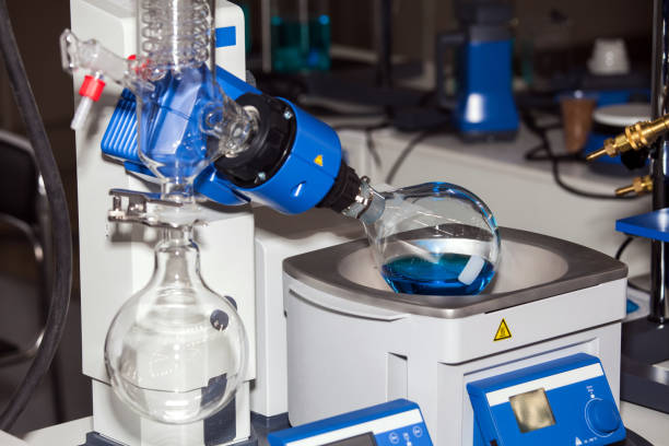 **Alt Text:** A laboratory rotary evaporator with a round-bottom flask containing blue liquid.