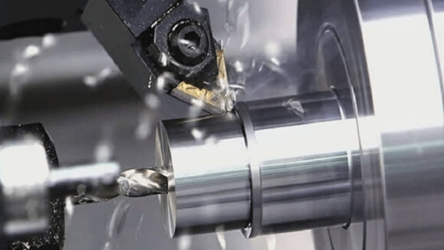A metal lathe cutting into a cylindrical workpiece, producing metal shavings.