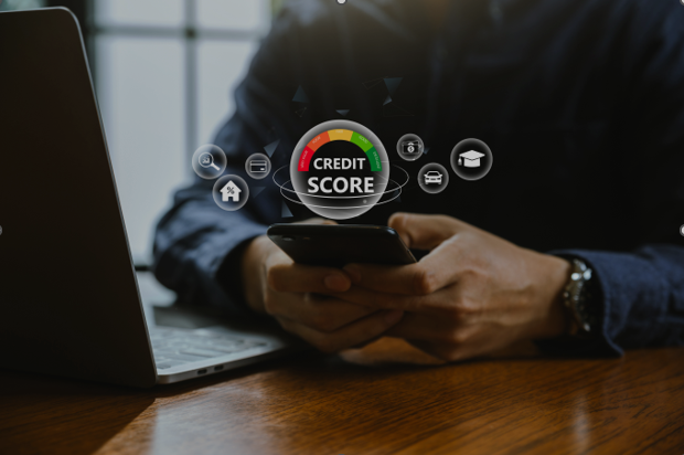 A person using a smartphone with a digital illustration of a credit score meter and financial icons hovering above.