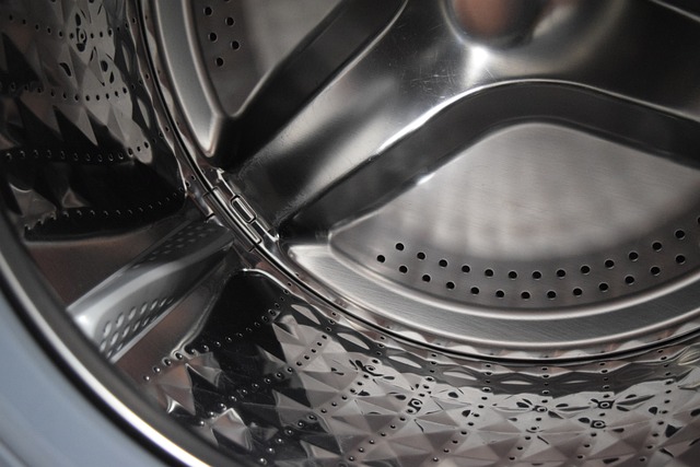 **Alt text:** Close-up of the interior of a stainless steel washing machine drum with perforated holes.