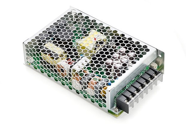 **Alt Text:** A metal-cased electronic power supply with a honeycomb mesh cover is shown, exposing internal components and connectors on one side.