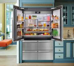 **Alt Text:** A modern stainless steel refrigerator with open doors revealing organized shelves filled with various beverages and food items in a brightly colored kitchen.