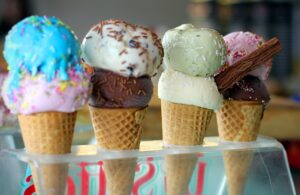 **Alt text:** Four ice cream cones with different colored scoops and toppings displayed in a row.