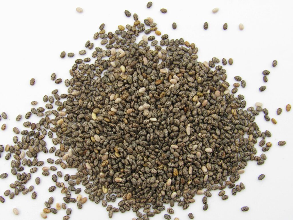 **Alt text:** A pile of chia seeds scattered on a white surface.