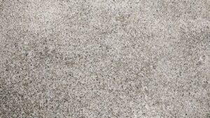 Close-up view of a speckled concrete surface with a rough texture.