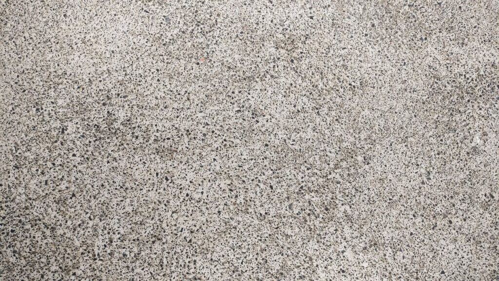 A close-up view of a rough, speckled concrete surface.