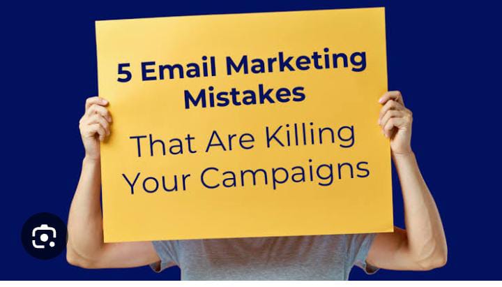 A person holds a yellow sign with the text "5 Email Marketing Mistakes That Are Killing Your Campaigns."