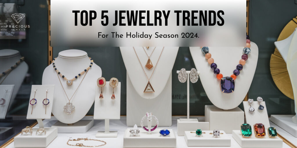Alt text: A display of various colorful jewelry sets, including necklaces, earrings, and rings, with a sign above reading "Top 5 Jewelry Trends For The Holiday Season 2024."