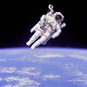 **Alt text:** An astronaut in a spacesuit floating above Earth with the planet's blue surface and white clouds visible below.