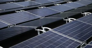 **Alt text:** Rows of blue solar panels arranged in parallel lines harness sunlight.