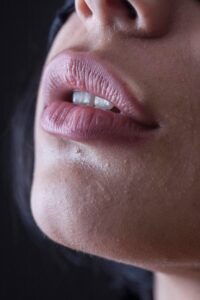 **Alt text:** Close-up of a person's lips and lower face, with a slight focus on the texture of the skin.