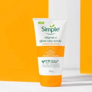 Alt text: A tube of Simple Vitamin C Glow Clay Scrub positioned against a bright orange and white background.