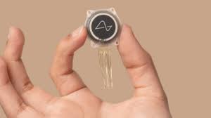 **Alt text:** A hand holding a small circular electronic device with several thin wires extending from it.