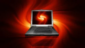 **Alt Text:** A laptop displaying a swirling red and yellow abstract pattern on its screen, set against a similar swirling red and yellow background.