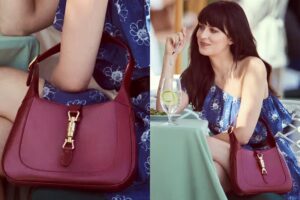 **Alt Text:** A woman in a blue floral dress is sitting at a table with a red handbag displayed prominently in front of her.