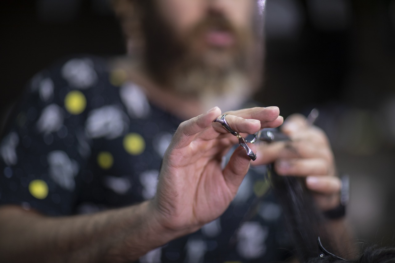 A barber holding scissors, preparing to cut hair.